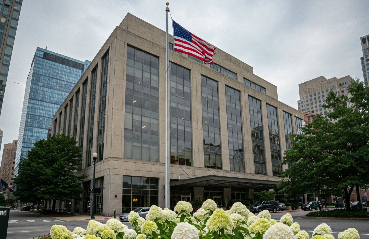 Large American flag on commercial flagpole outside business in downtown area