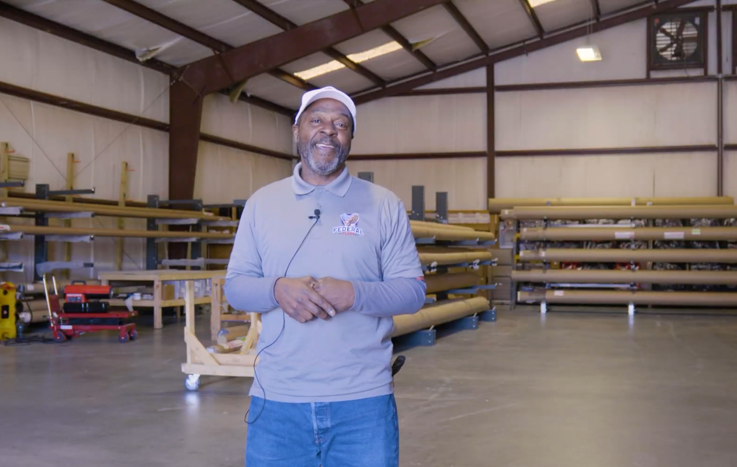 Logistics manager standing in American flagpole warehouse surrounded by shipping materials